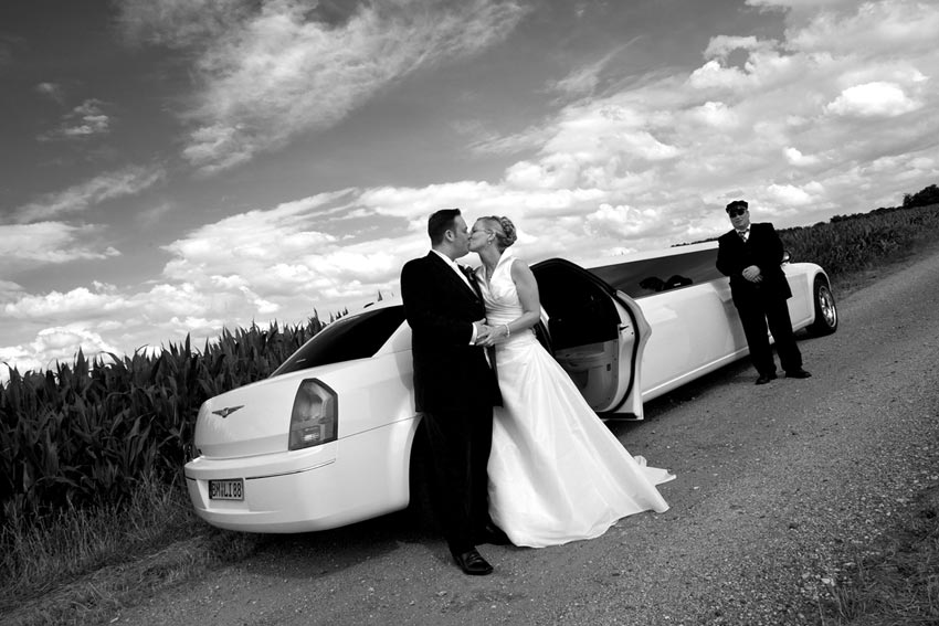 Bridal couple and limo at corn field