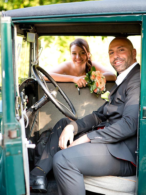 Groom behind the wheel of a vintage car