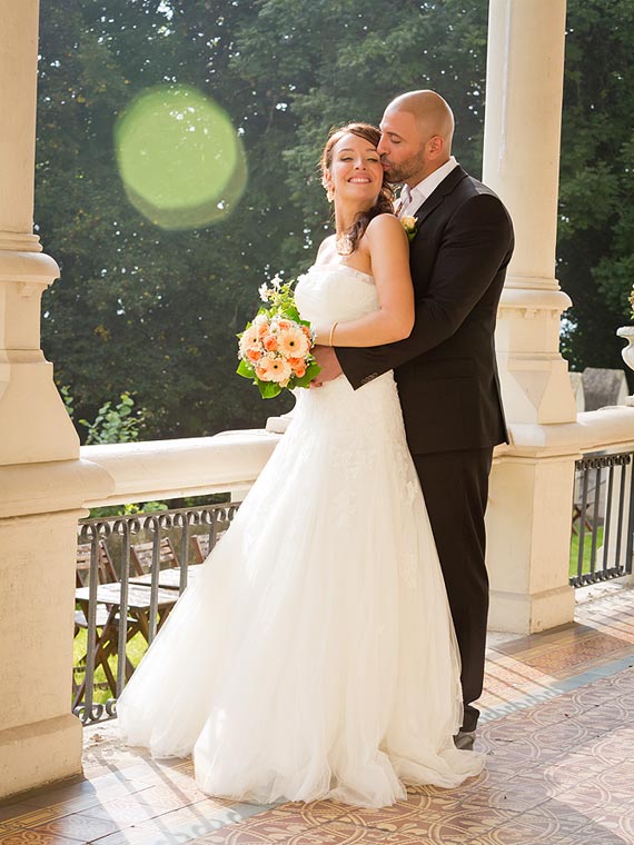 Groom holding the bride in the backlight of the sun